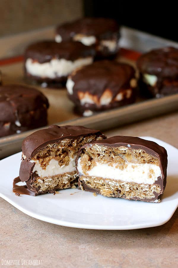 Homemade Chocolate Covered Ice Cream Sandwiches made with oatmeal cookies cut in half on a white plate.