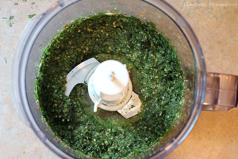 Homemade carrot top pesto in the bowl of a food processor.