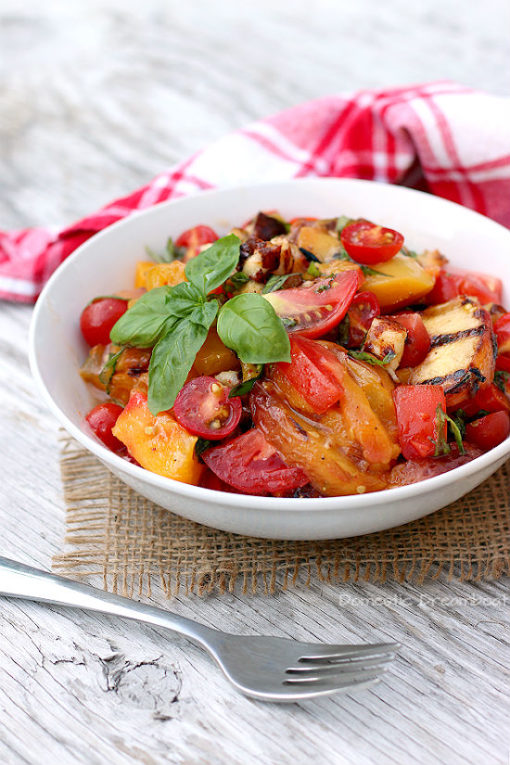 caprese salad with grilled peaches and halloumi in a white bowl