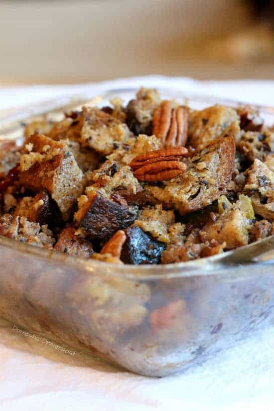 Close-up photo of Bread Stuffing with Dried Cranberries and Pecans in a glass baking dish.