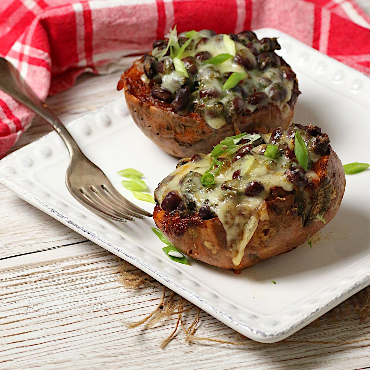 Chipotle Black Bean Sweet Potato Skins Two Chipotle Black Bean Sweet Potato Skins on a square white plate.