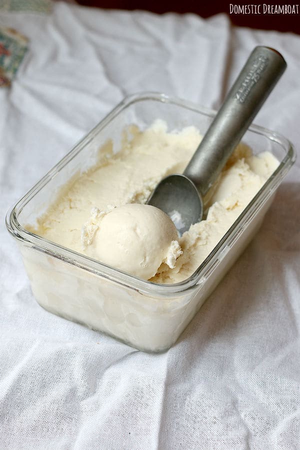 Homemade vanilla ice cream being scooped out of a glass dish