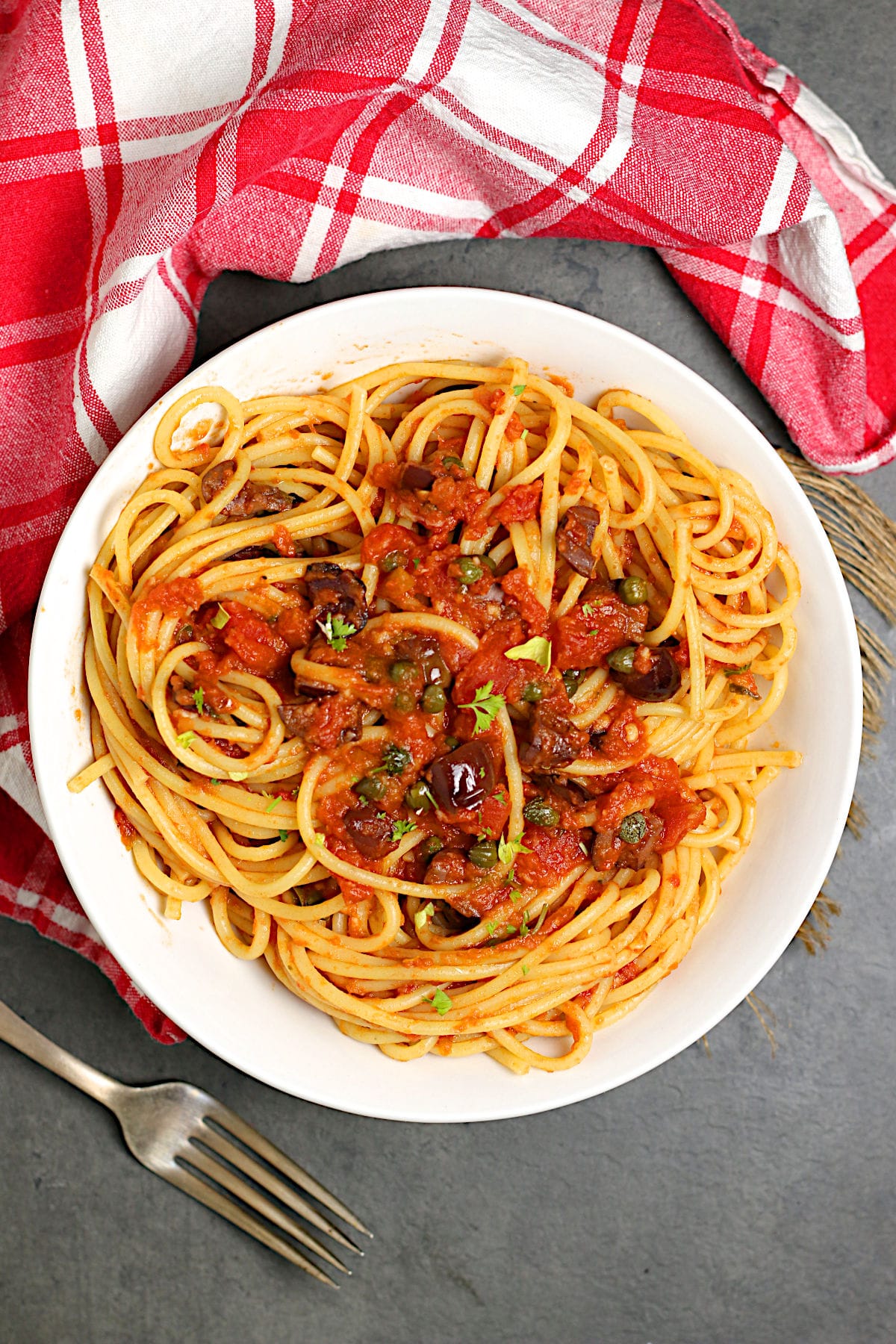 Overhead photo of Spaghetti Puttanesca in a white bowl.