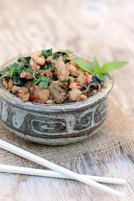 Close up photo of Spicy Thai Basil Chicken in a bowl with chopsticks