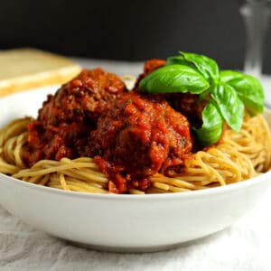 Spaghetti and meatballs in a white bowl
