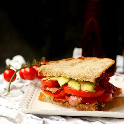 Bacon, Avocado, and Tomato Sandwich on a white plate