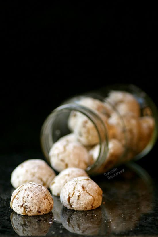 Almond apricot cookies spilling out of a glass jar.