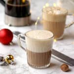 Two eggnog lattes in clear glass mugs