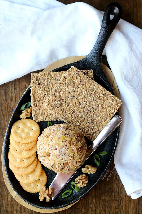 An overhead photo of a homemade cheese ball and crackers on a serving platter.
