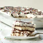 Slice of ice cream sandwich cake with sprinkles and chocolate on plate