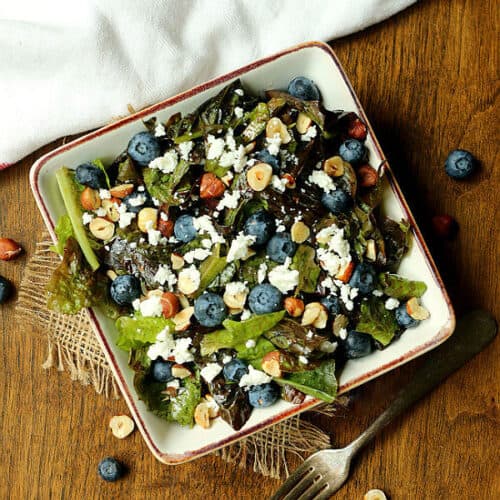 Overhead photo of salad with blueberries, feta cheese, and hazelnuts in a bowl