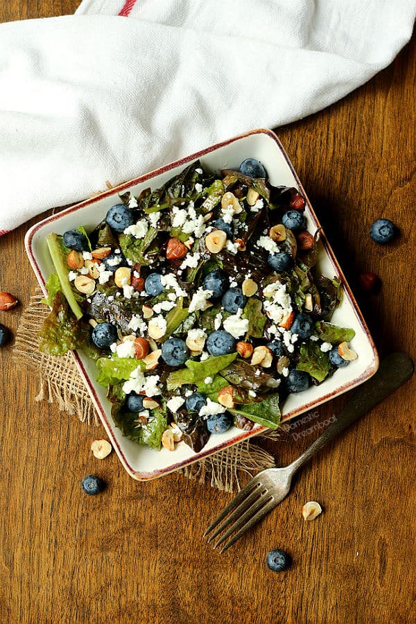 Overhead photo of salad with blueberries, feta cheese, and hazelnuts in a bowl