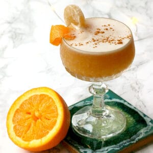 cropped photo of an orange whisky sour cocktail