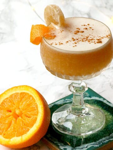 cropped photo of an orange whisky sour cocktail