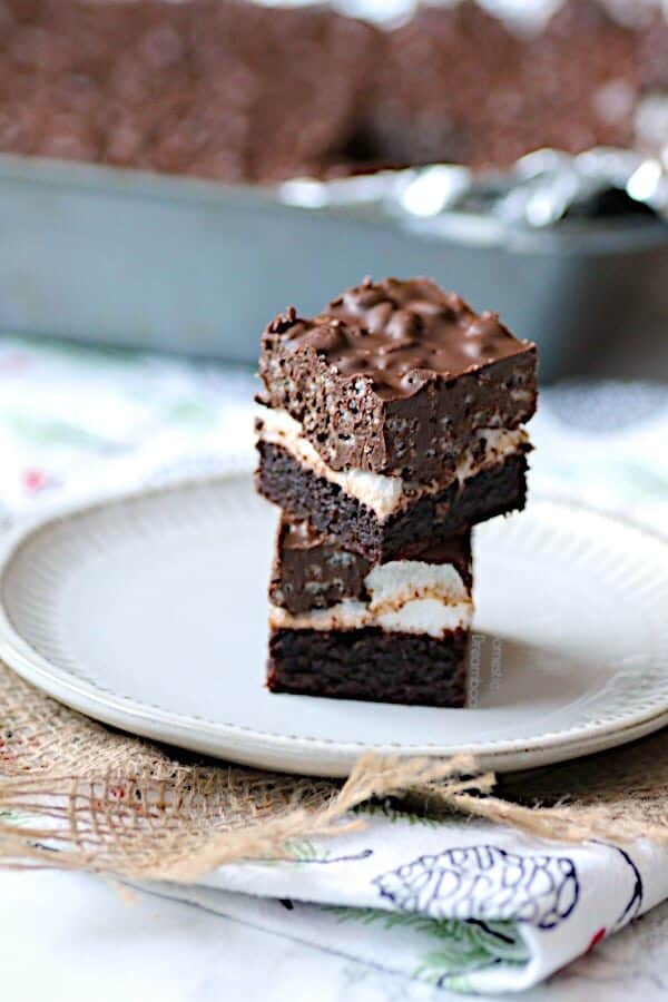 A stack of chocolate peanut butter brownies on a white plate