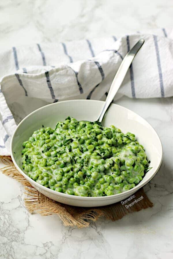 Creamed peas in a white bowl.