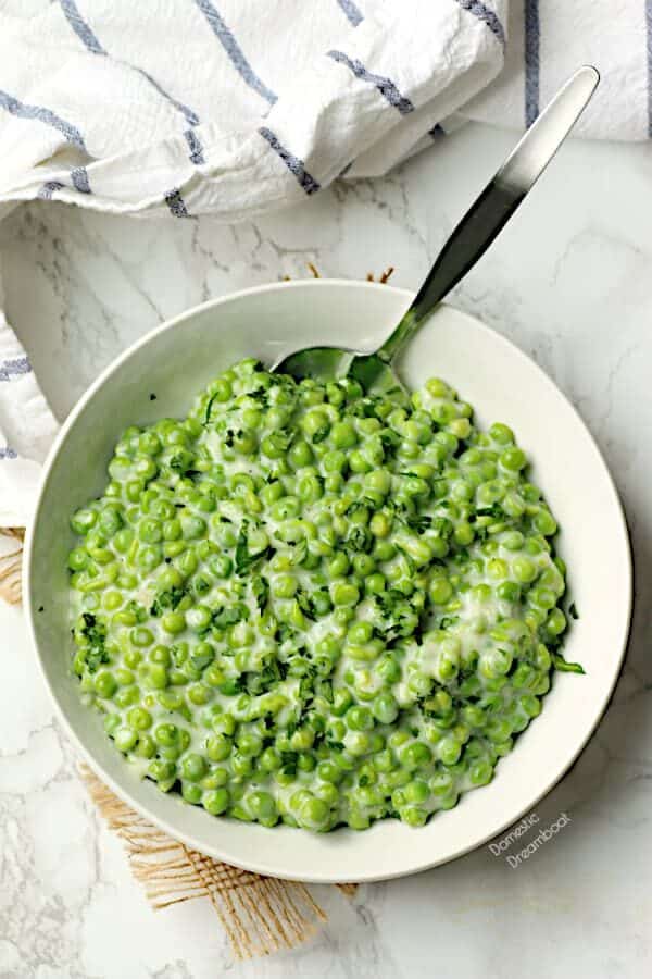 Overhead photo of creamed peas in a white bowl.