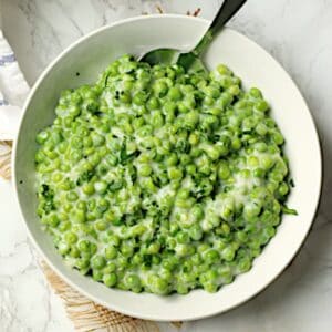 Overhead bowl of creamed peas in a white bowl.