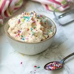 Edible sugar cookie dough with sprinkles in a white bowl.