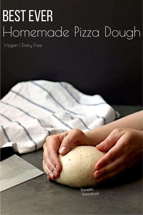 Hands shaping a ball of pizza dough.