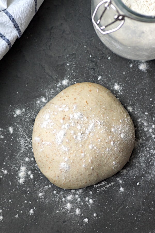 A ball of pizza dough with flour sprinkled on top