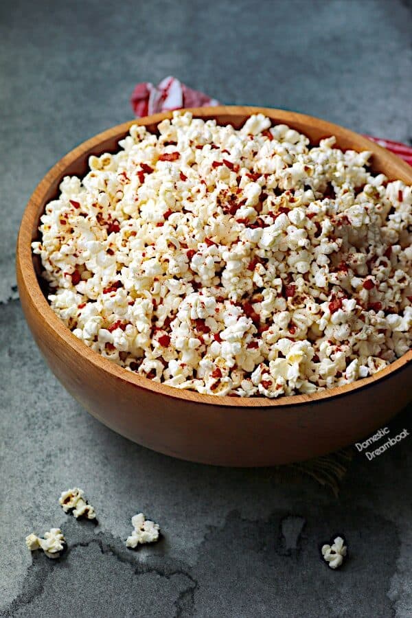 A large wooden bowl filled with popcorn.