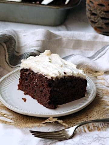A slice of chocolate zucchini cake on a white plate