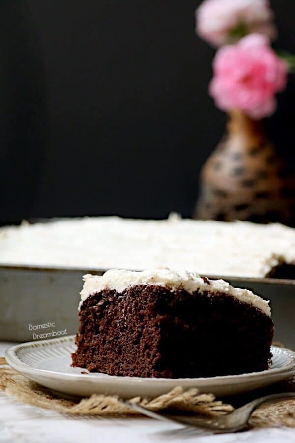 A slice of chocolate zucchini cake on a white plate