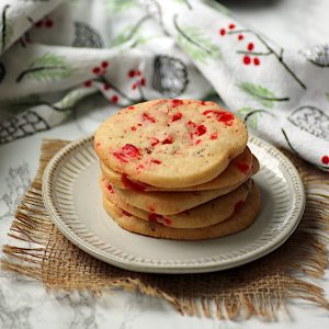 A stack of cherry pecan icebox cookies on a white plate.