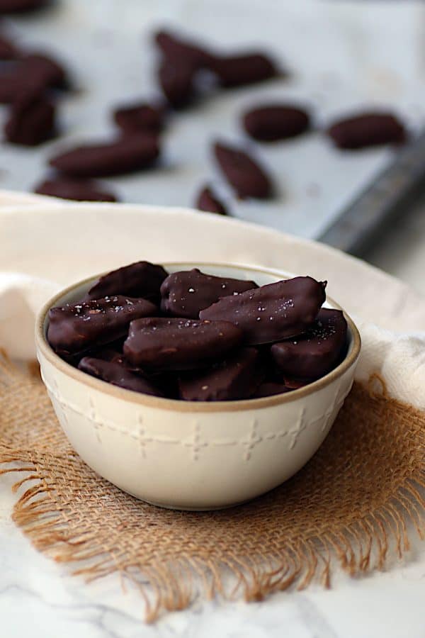 Chocolate covered dates in a white bowl.