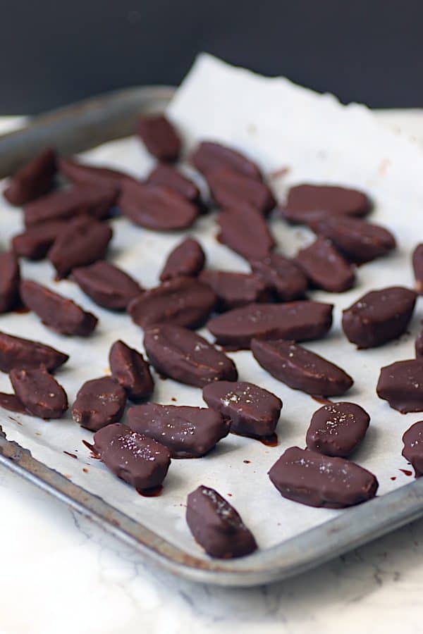 Chocolate covered dates on a baking sheet.