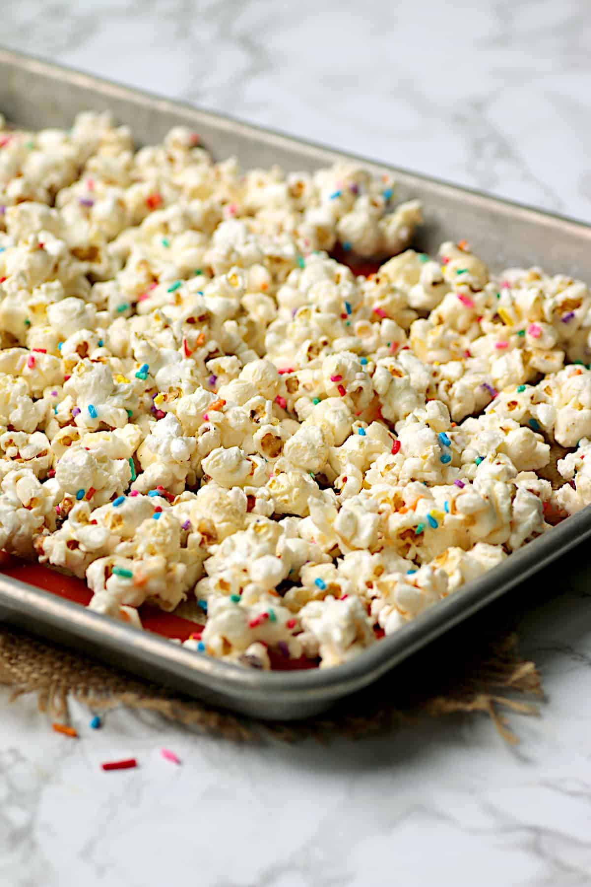 Homemade funfetti popcorn on a baking sheet.