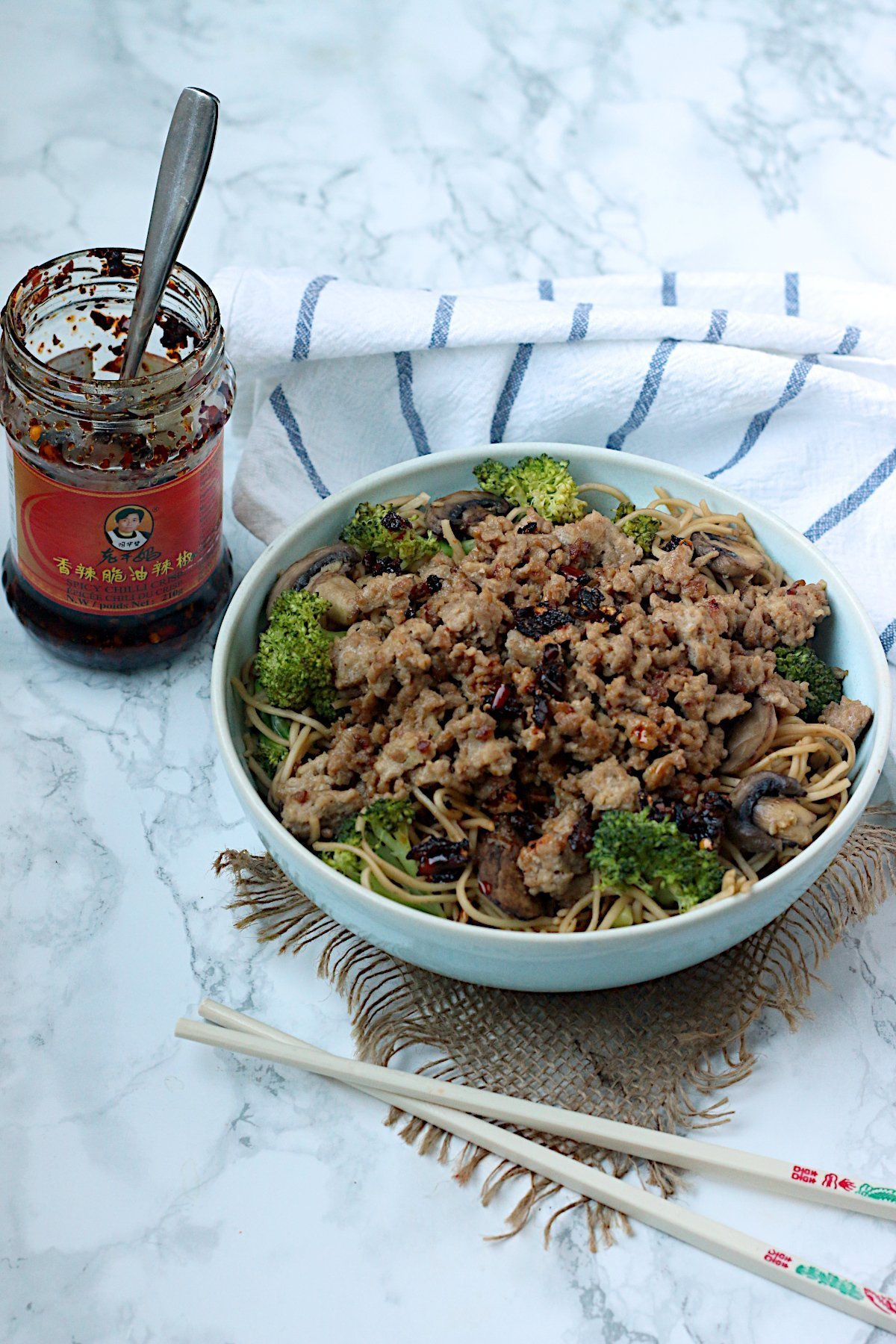 One-Pan Pork and Broccoli Noodle Bowl garnished with chili oil.
