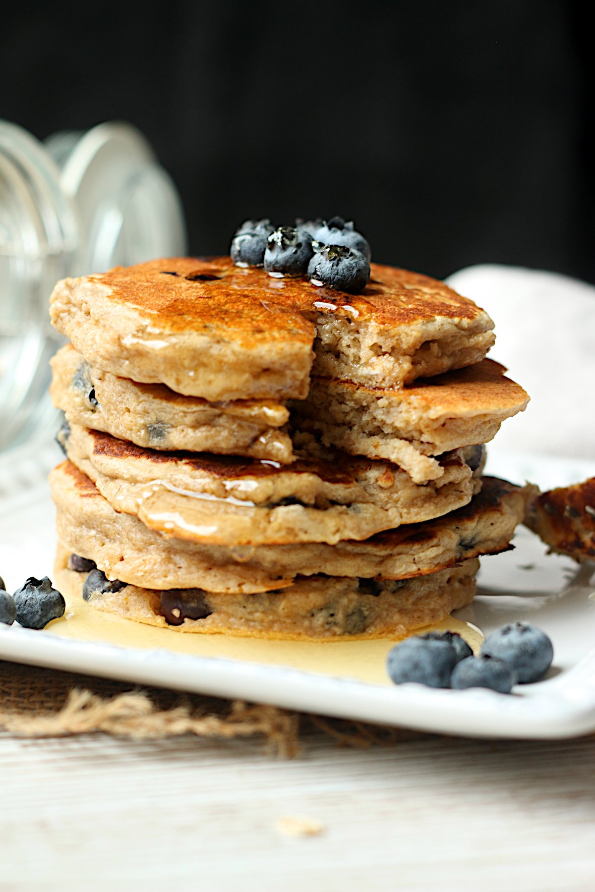 A stack of blueberry oatmeal pancakes with syrup