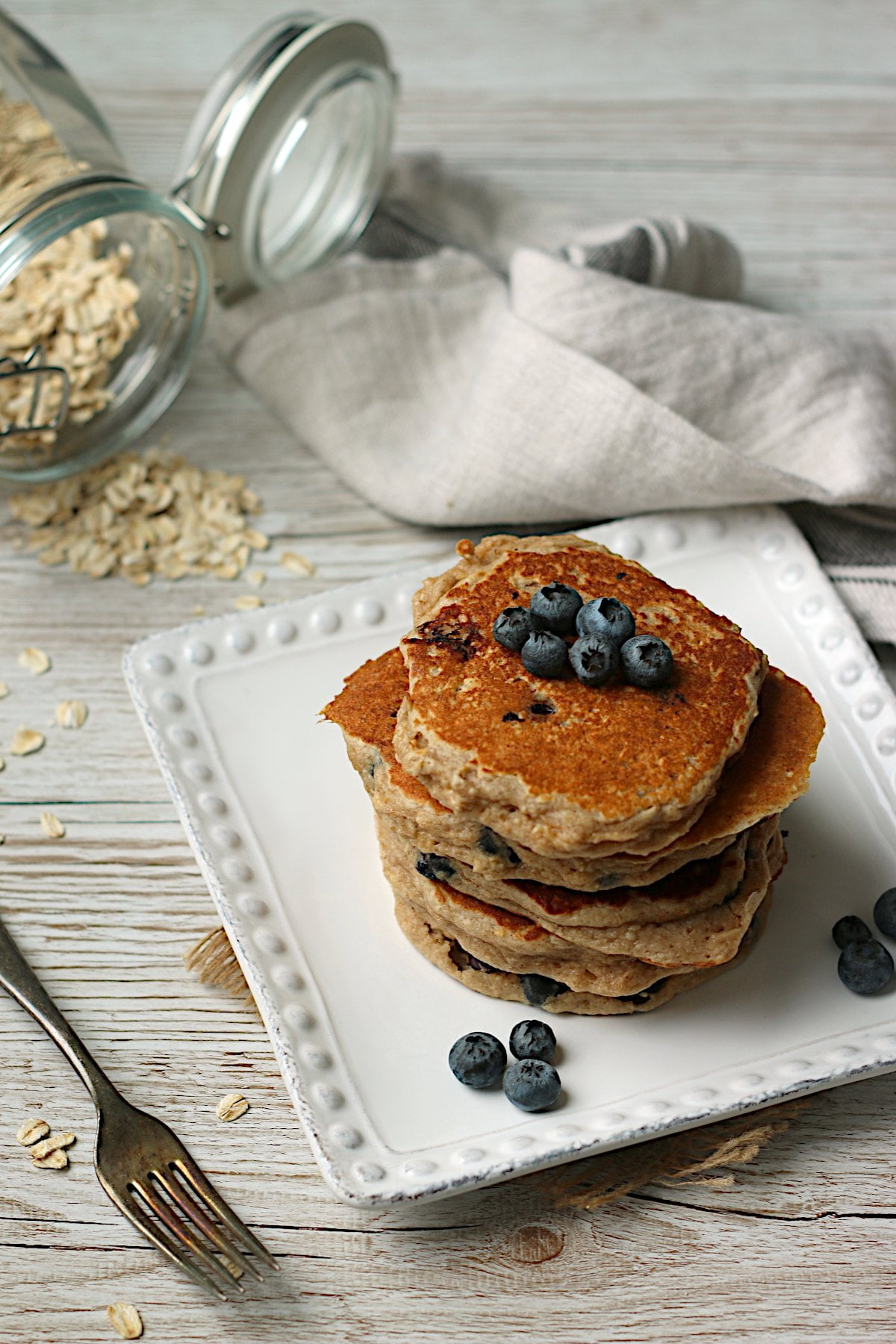 Blueberry oatmeal pancakes on a white plate.