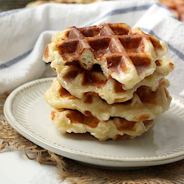 A stack of honey cruller waffles on a white plate.