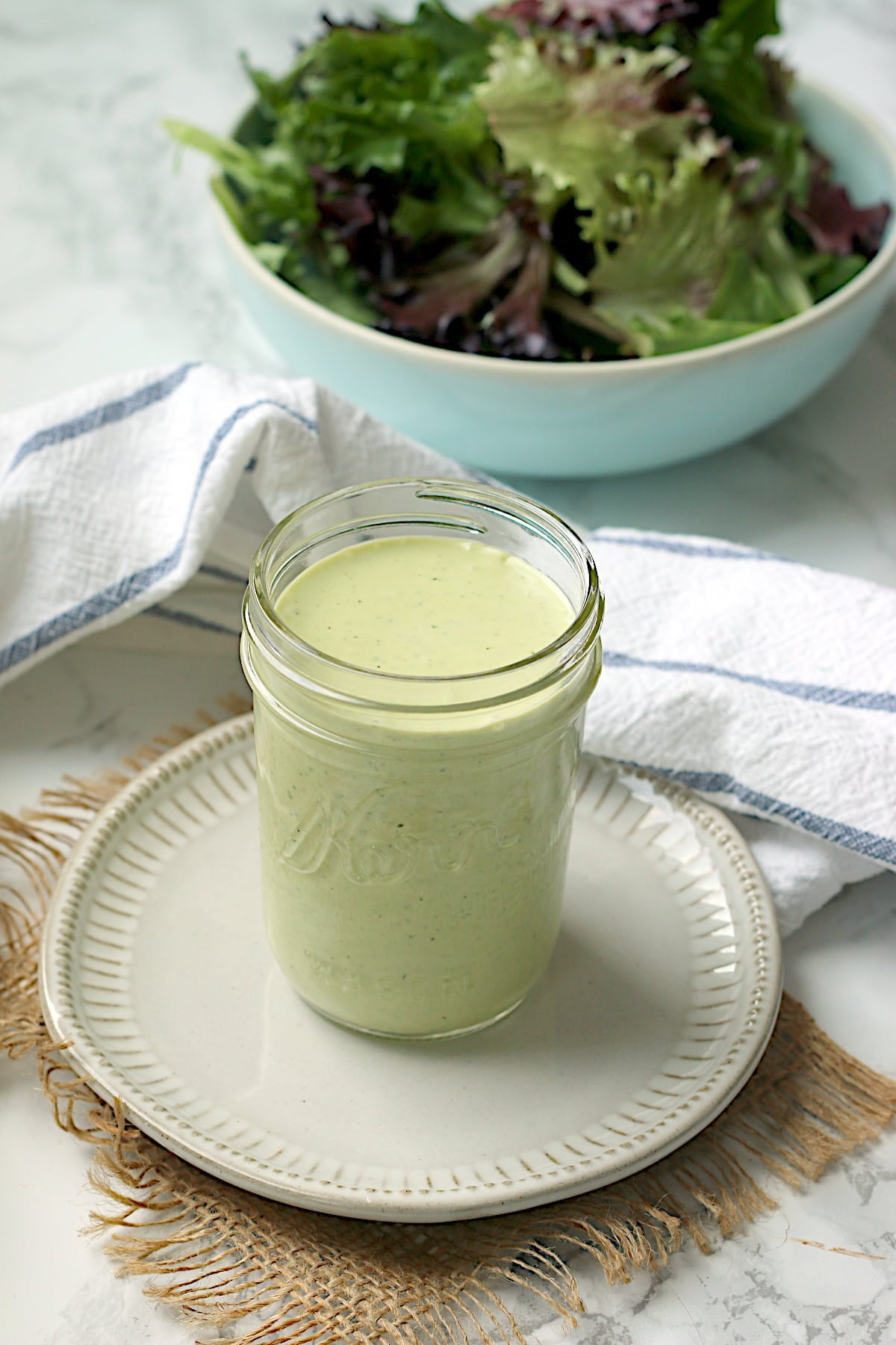 Homemade creamy pesto salad dressing in a jar.