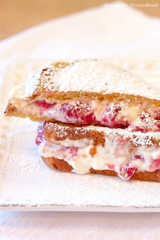 Cherry Cheesecake Stuffed French Toast topped with powdered sugar on a white plate.