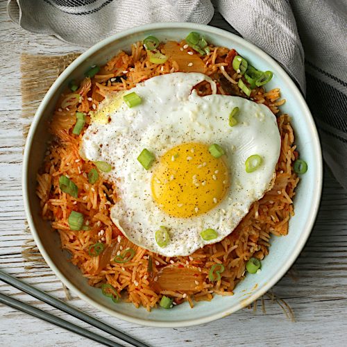 Overhead photo of a bowl of homemade kimchi fried rice with a sunny-side up egg.