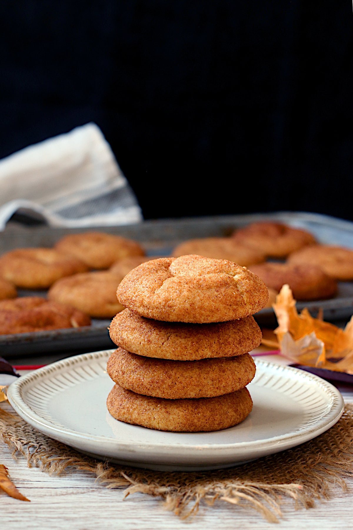 A stack of pumpkin spice snickerdoodles on a white plate.
