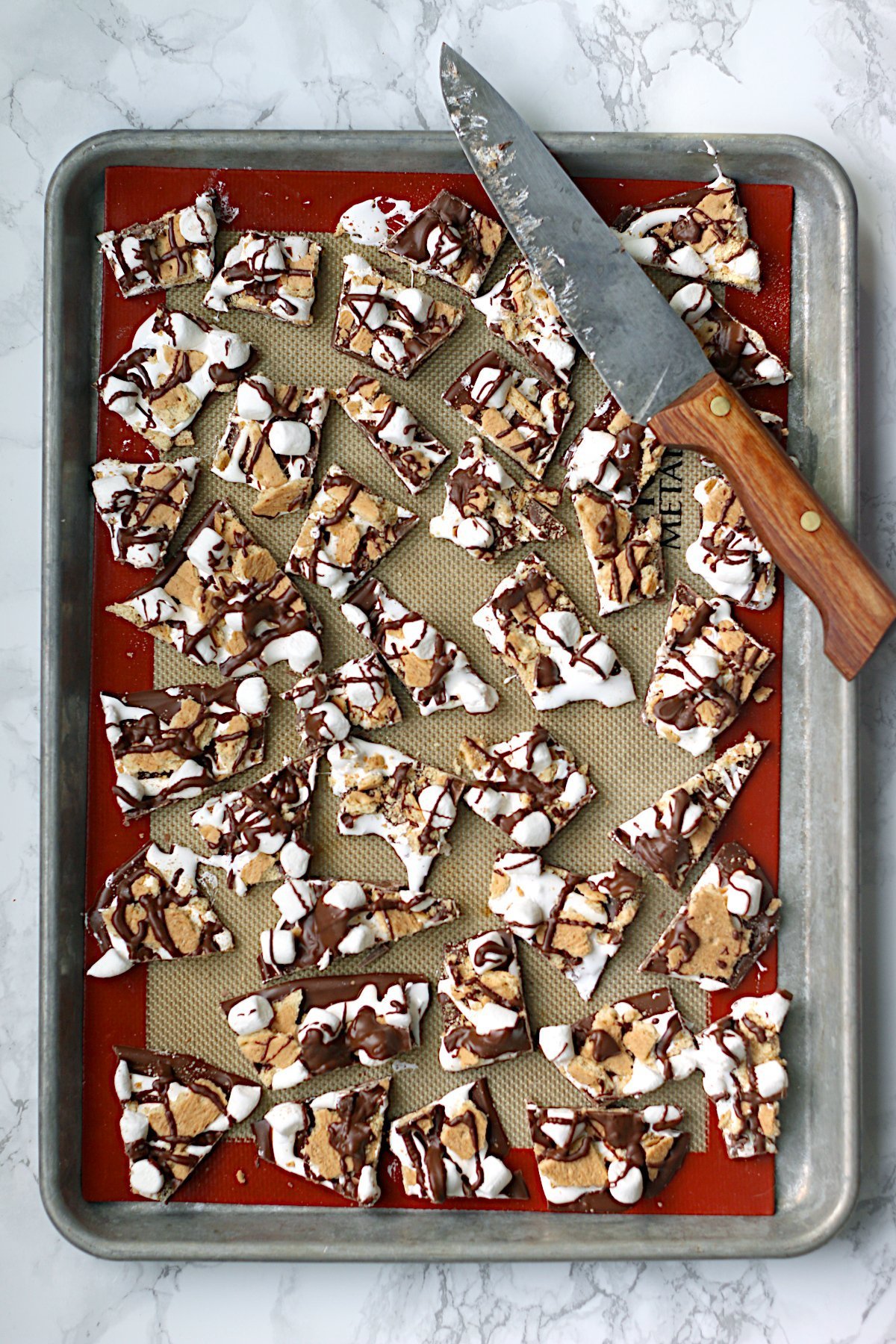An overhead photo of pieces of smores bark on a baking sheet.