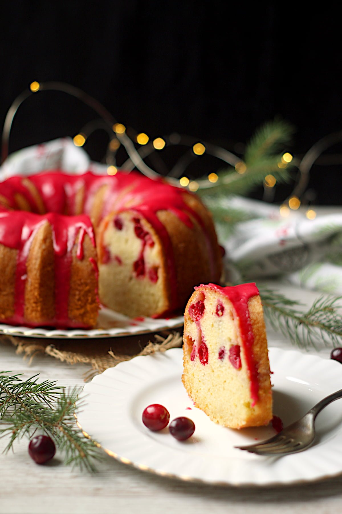 A slice of Cranberry Orange Bundt Plate on a small white plate.