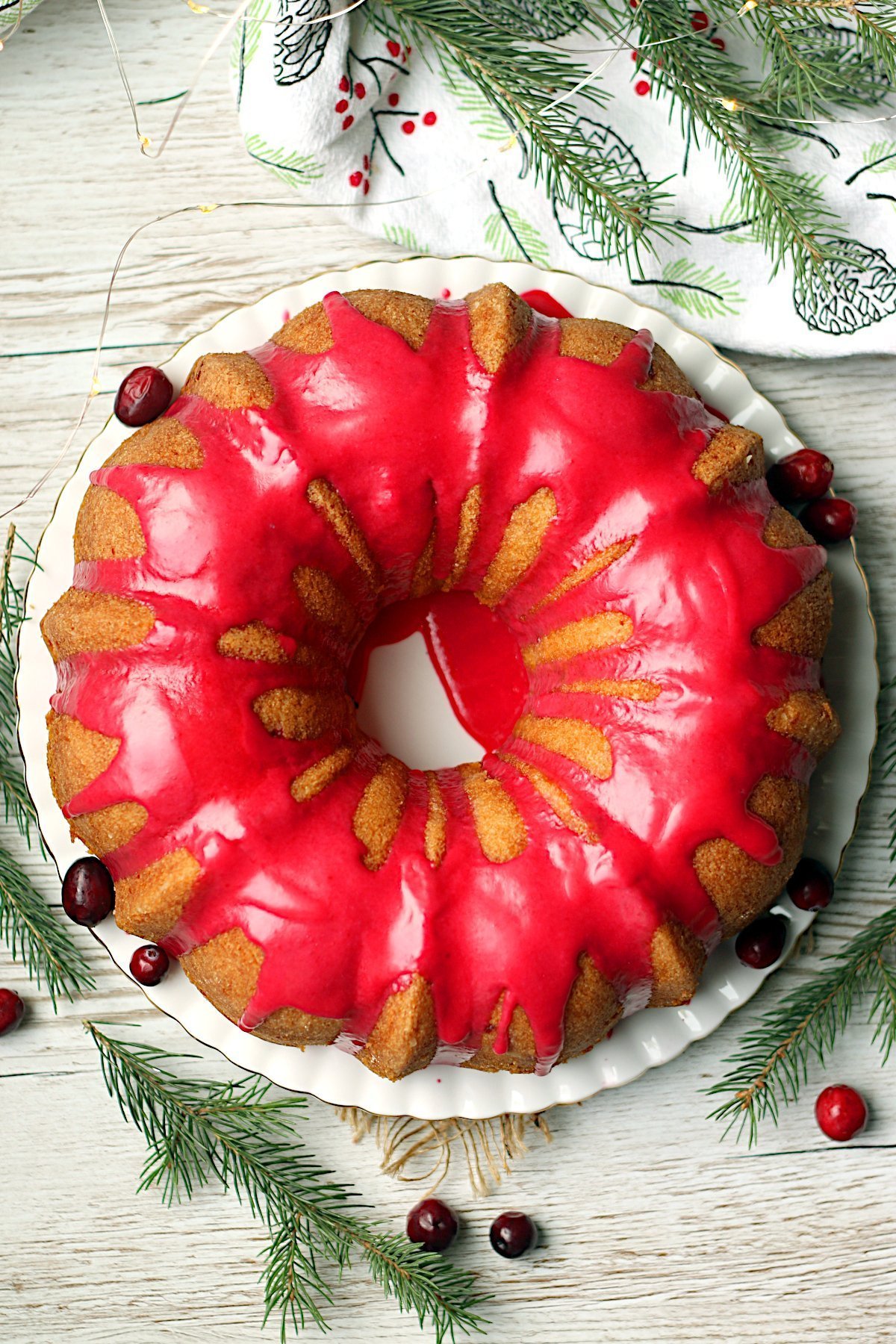 An overhead photo of A whole Cranberry Orange Bundt cake with bright pink cranberry glaze.