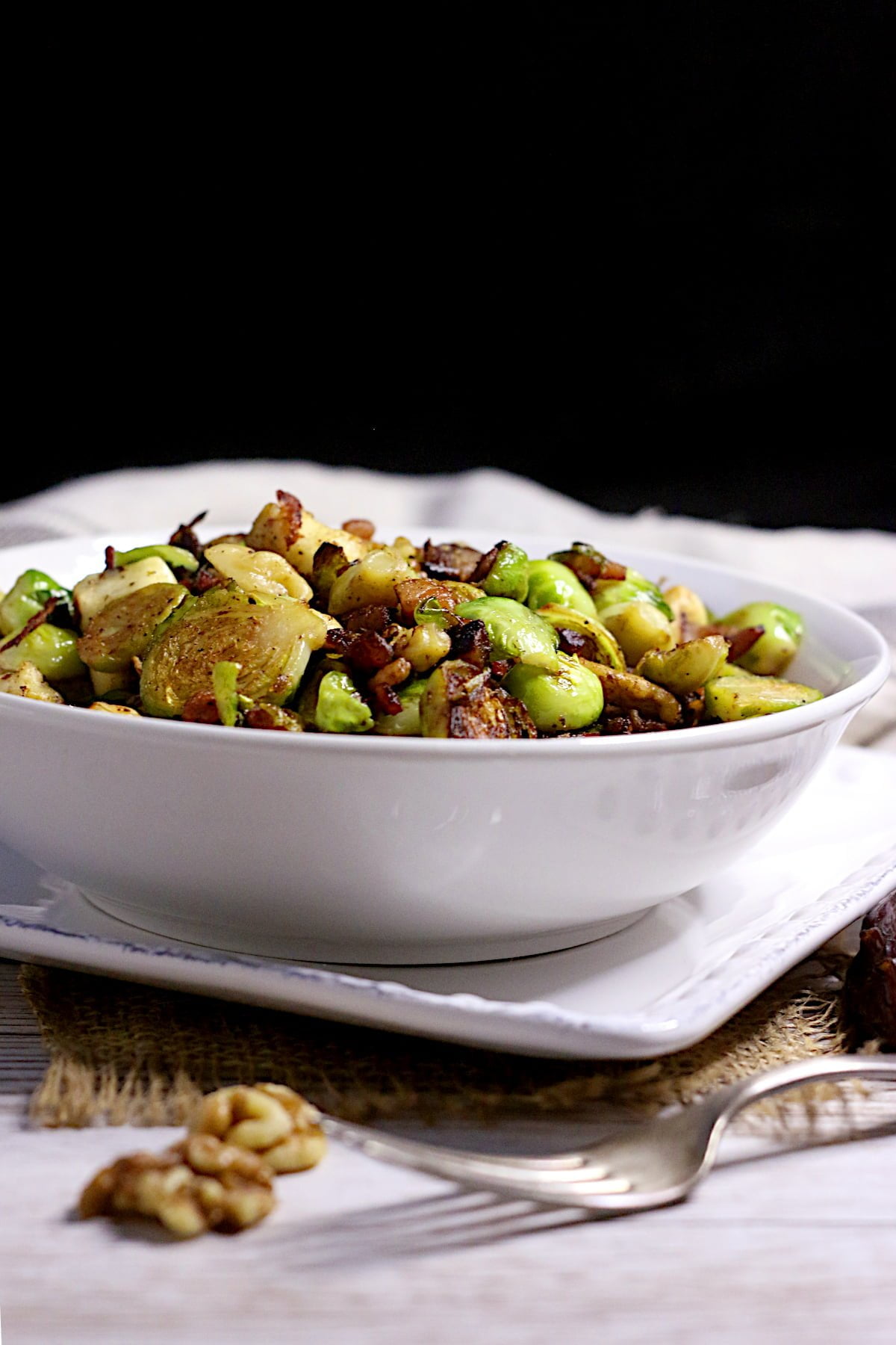 Brussels Sprouts with Bacon, Halloumi, and Dates in a white bowl.