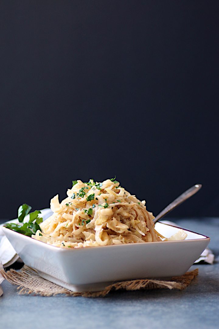 Creamy Caramelized Cabbage in square, off-white bowl.