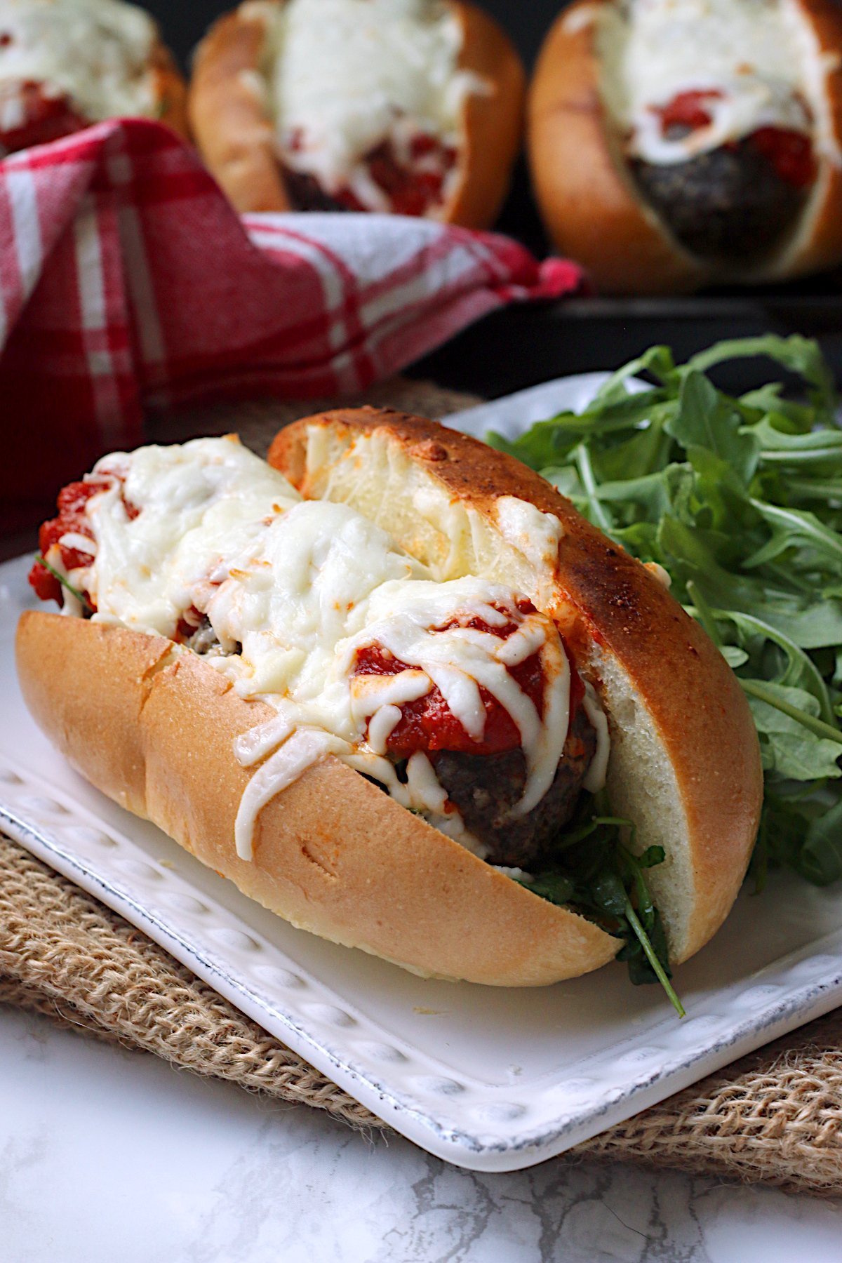 Meatball sub on a square white plate.