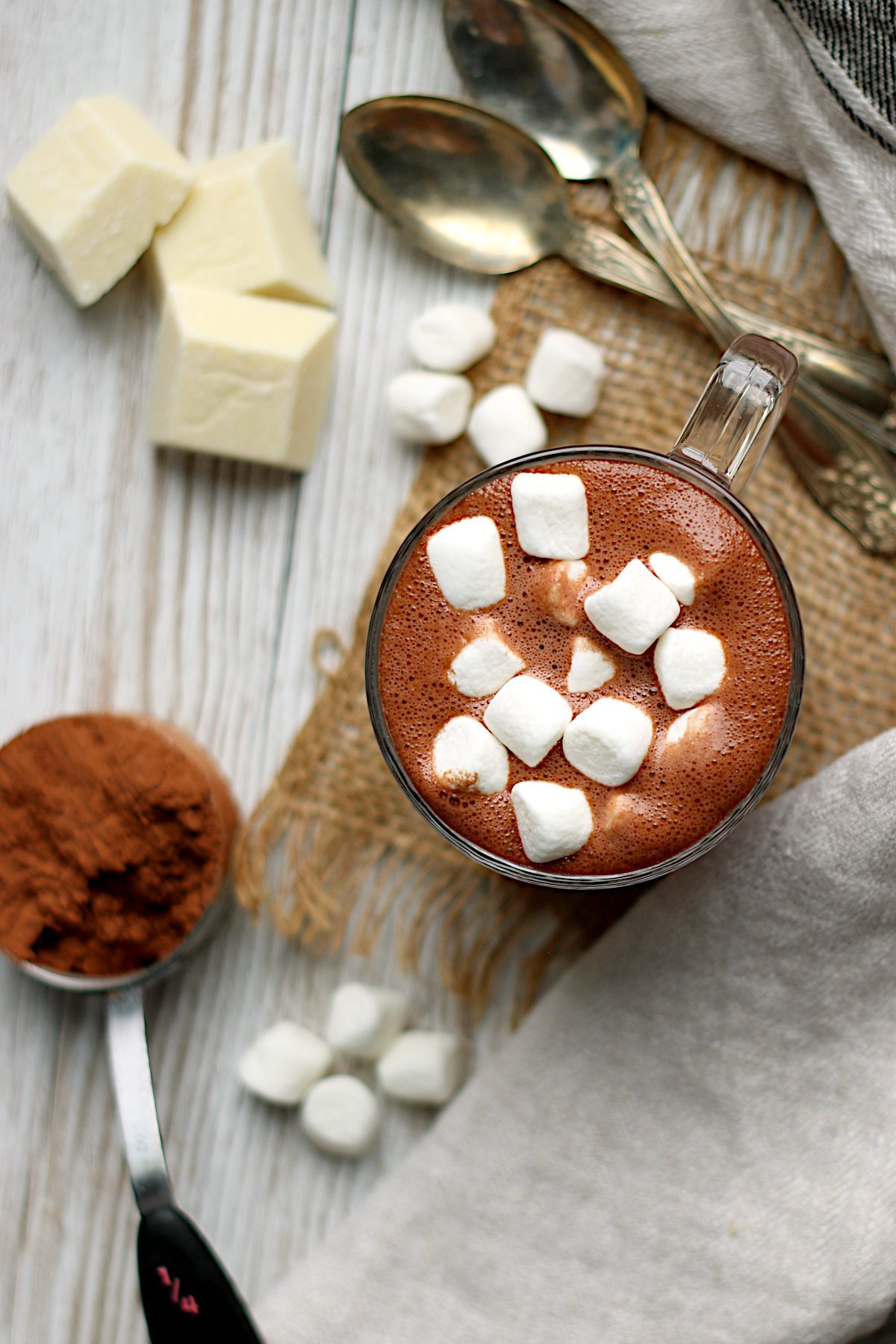 Overhead photo of homemade hot chocolate with mini marshmallows in a clear glass mug.