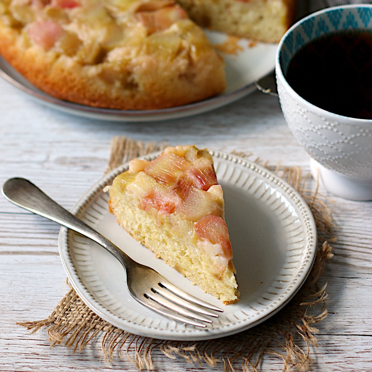 Cornmeal Rhubarb Upside-Down Cake A slice of Cornmeal Rhubarb Upside-Down Cake on a small, white plate.