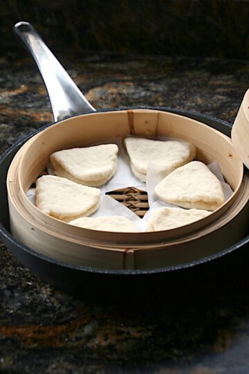 Bread dough to make Steamed Lotus Leaf Buns rising in a bamboo steamer.