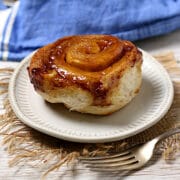 A homemade Overnight Sticky Bun on a small, white plate.